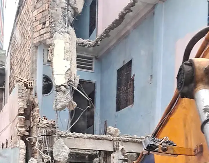 Máy xúc đập kết cấu bê tông tại công trình phá dỡ nhà phố Thuận An.